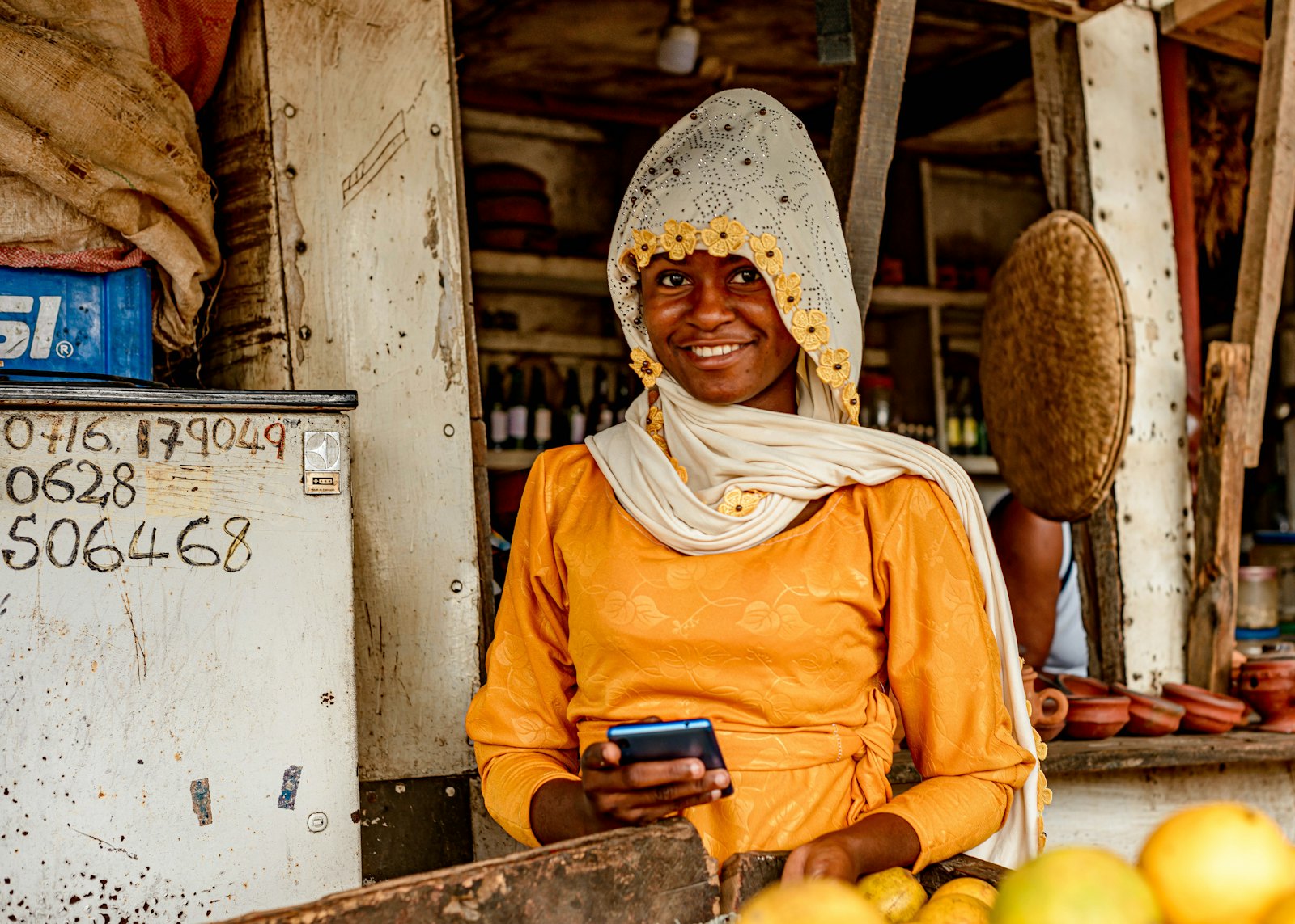 Commerçante ivoirienne qui utilise son smartphone pour vendre en ligne